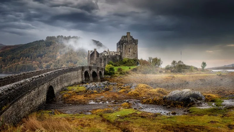 Panoramic view of the impressive Eilean Donan castle during a moody autumn day with fog and clouds, Scotland