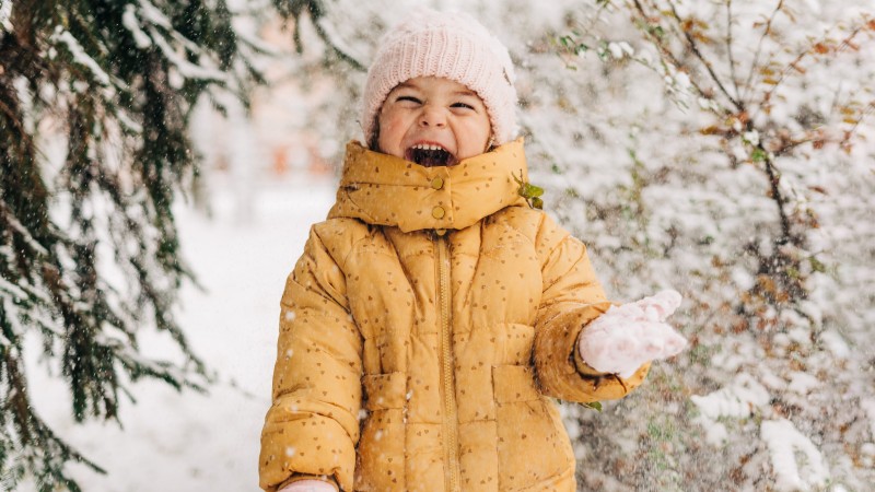 Toddler girl happy with snow day in winter.