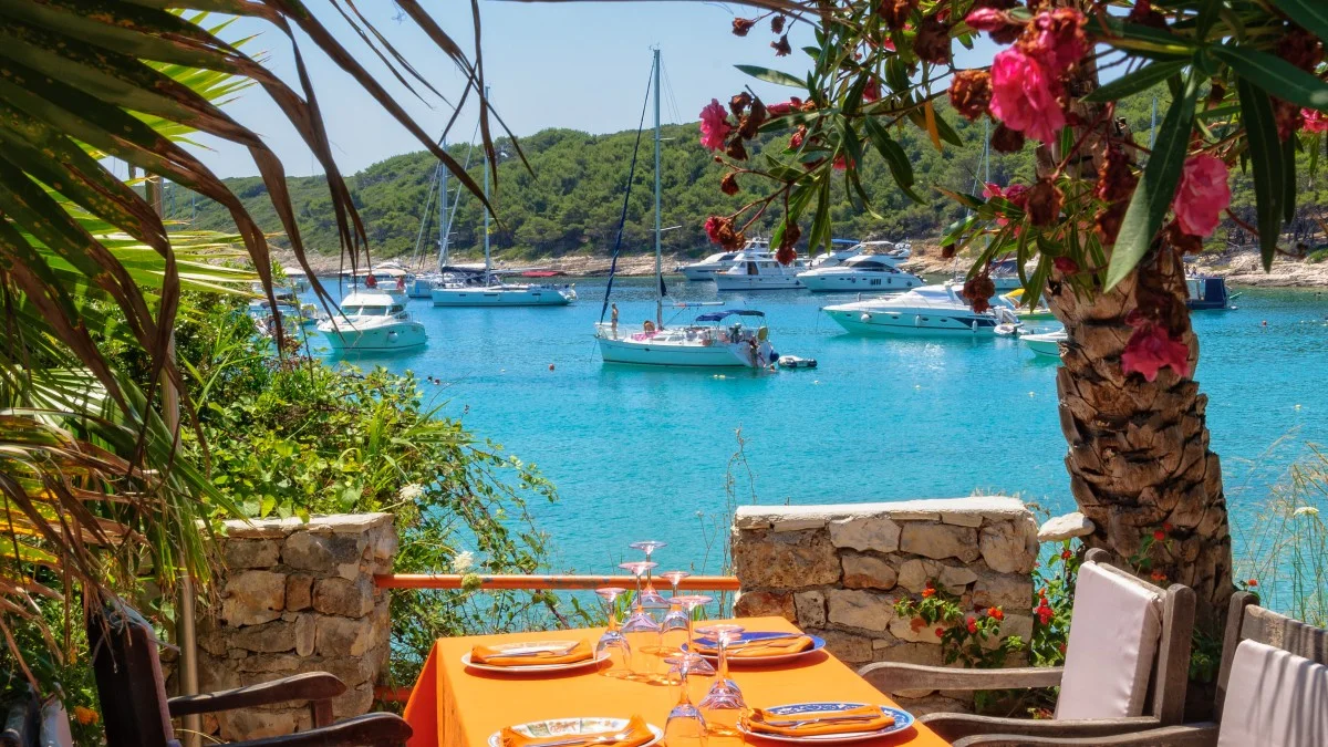 Yachts on anchor in Milne Bay photographed from the terrace of a restaurant - Hvar, Croatia