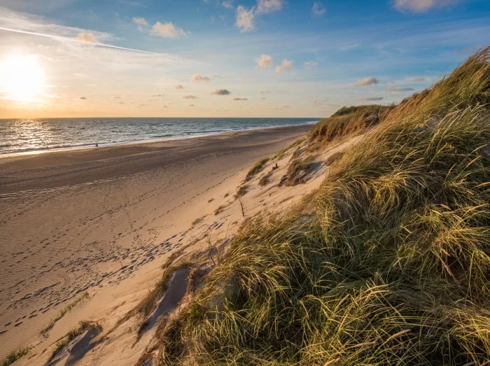 En strand i solnedgang langs kysten i Jylland.