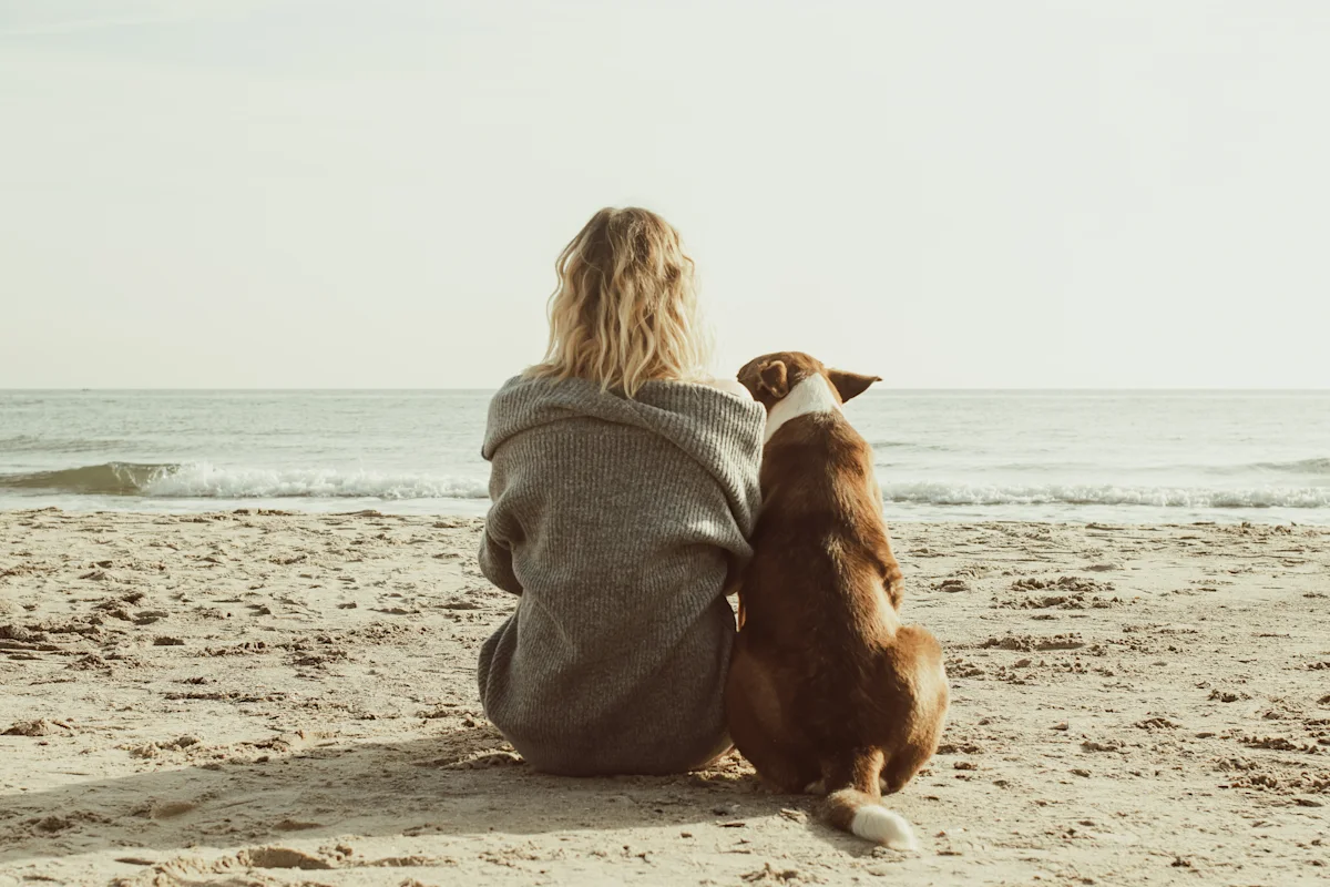 Hund und Frau am Strand im OstseeResort Olpenitz