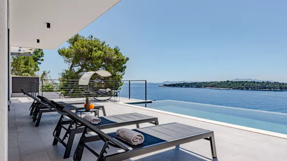 Terrasse mit Sonnenliegen und Blick auf das Meer in Kroatien.