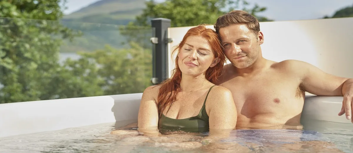 Couple relaxing in a hot tub at Loch Lomond Holiday Park in Argyll, Scotland
