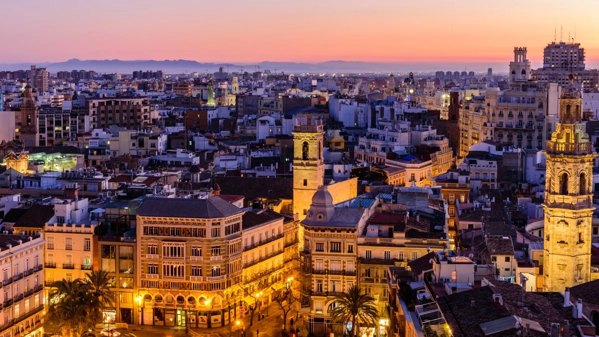 Sightseeing of Spain. Aerial view of Valencia at sunset. Illuminated Plaza de la Reina, cityscape of Valencia.