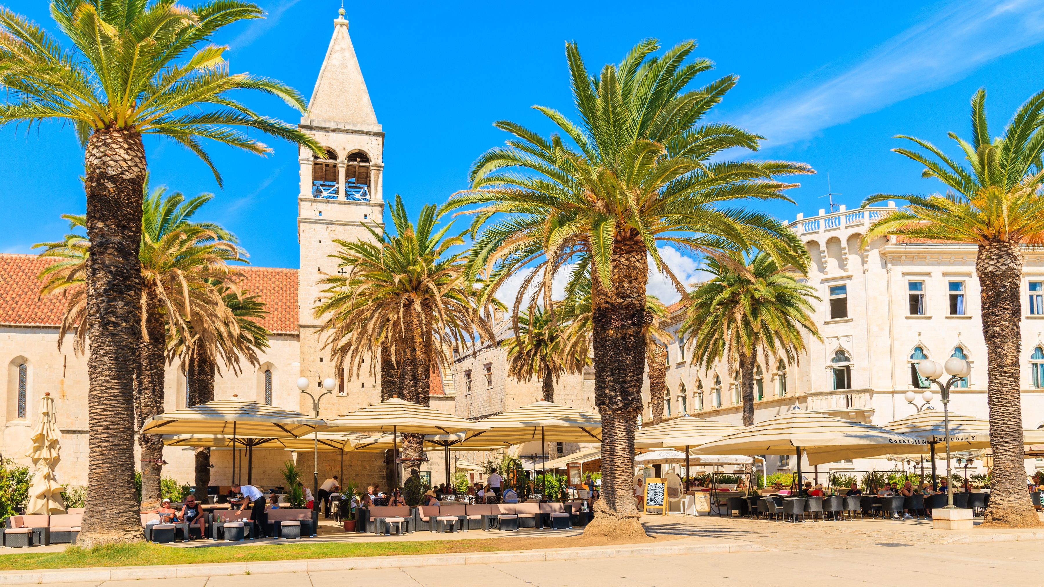 Historiske bygninger og kirke i den gamle bydel i Trogir på en solrig sommerdag.