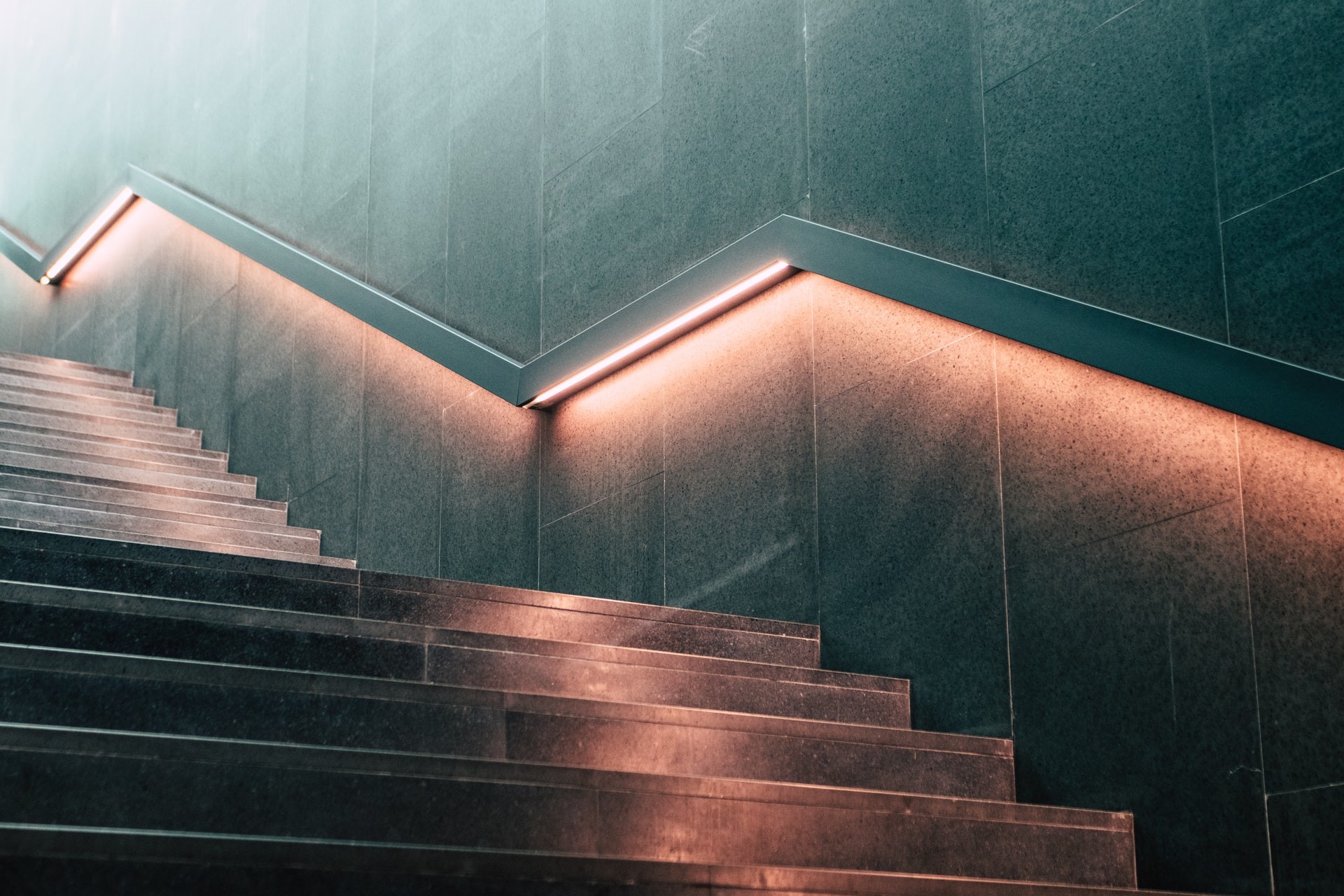 a long flight of stairs with backlit handrails