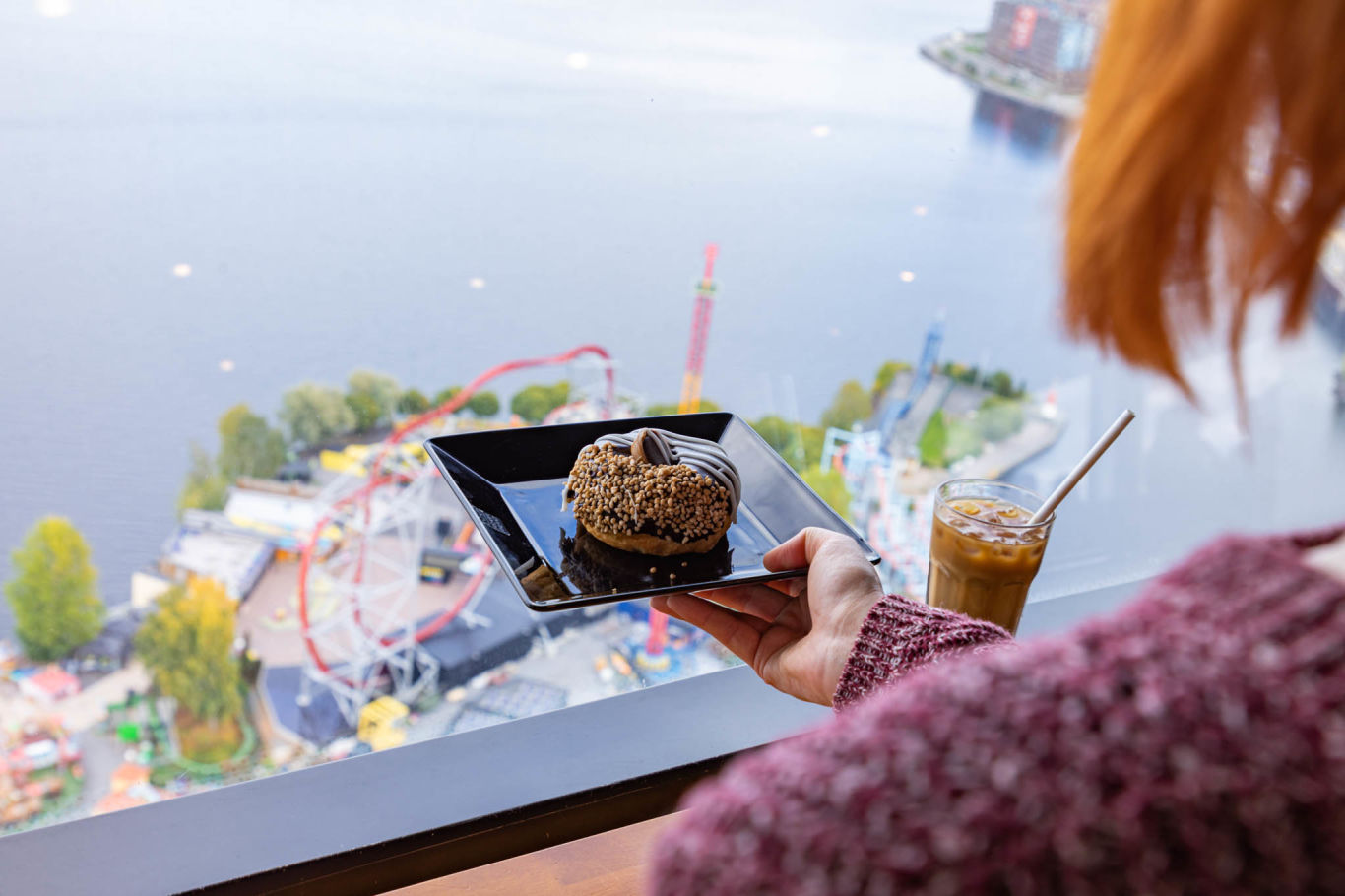 Nainen ja kahvilaherkkuja Särkänniemen Neula Sky Cafessa.