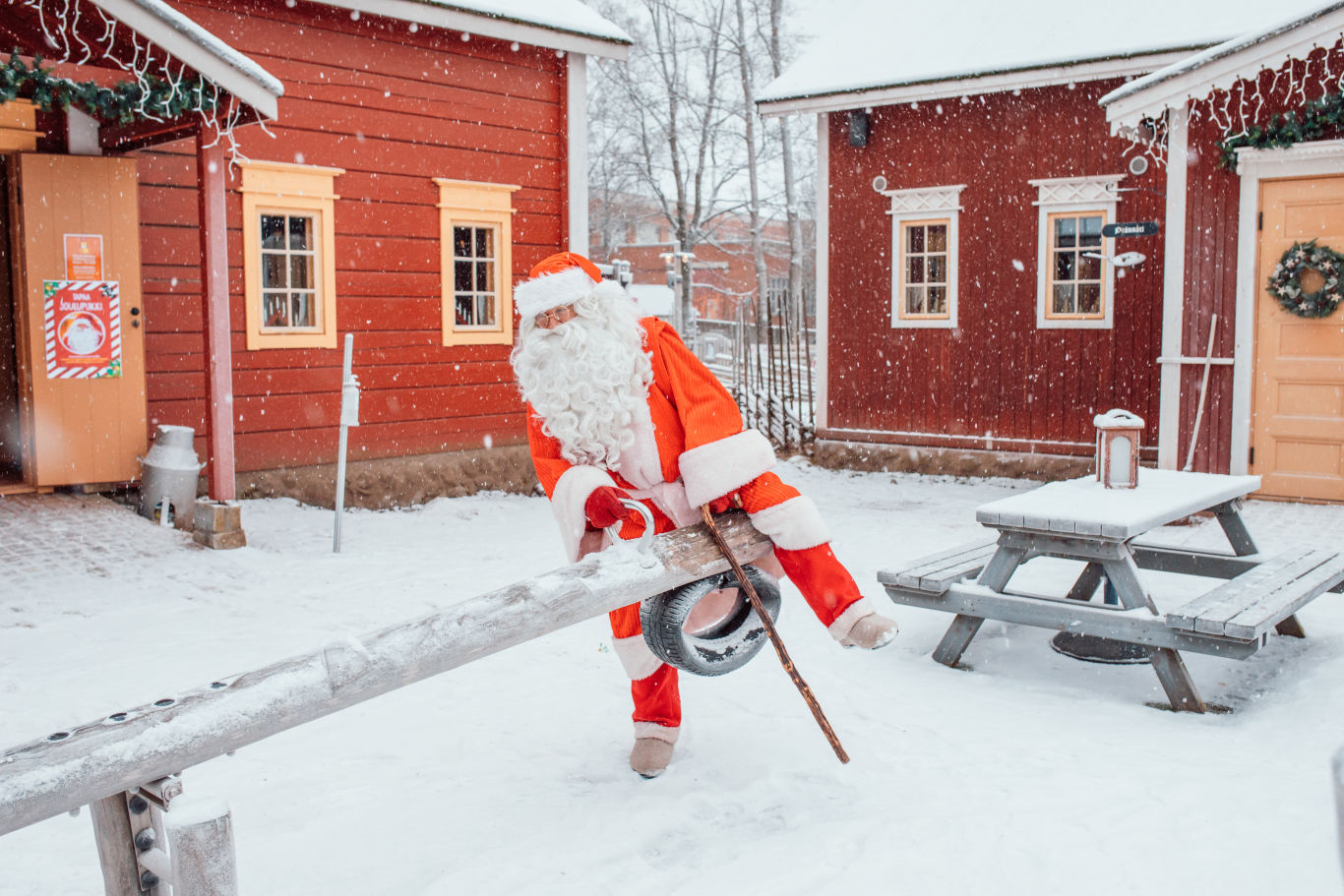 Joulupukki Särkänniemen Koiramäen keinulaudalla lumisessa maisemassa.