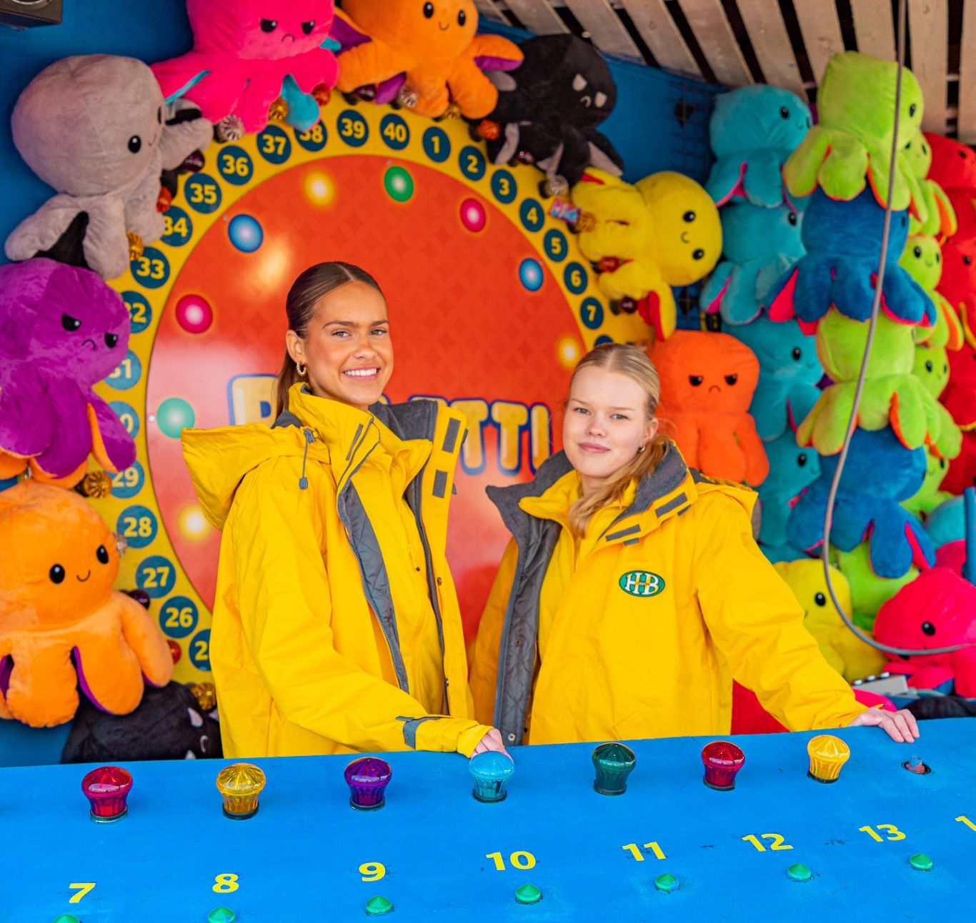 Two women in front of Särkänniemi's Roulette game wearing yellow jackets.