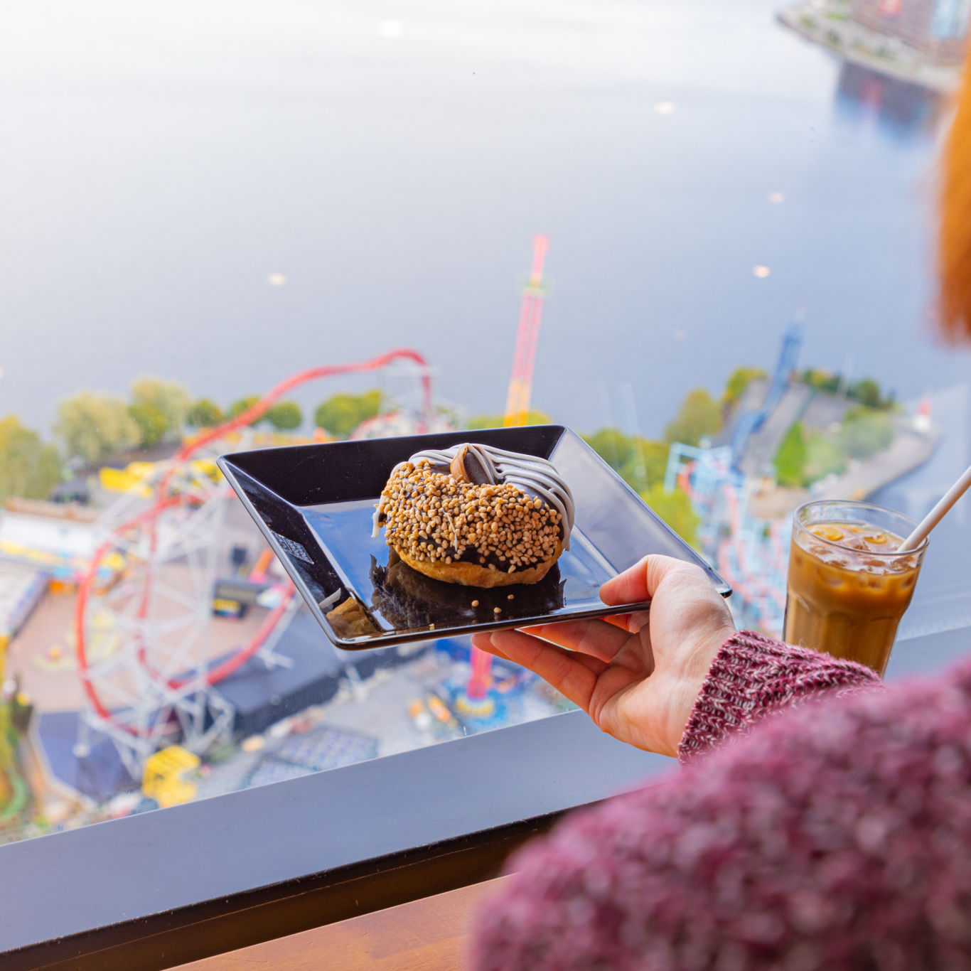 Nainen ja kahvilaherkkuja Särkänniemen Neula Sky Cafessa.