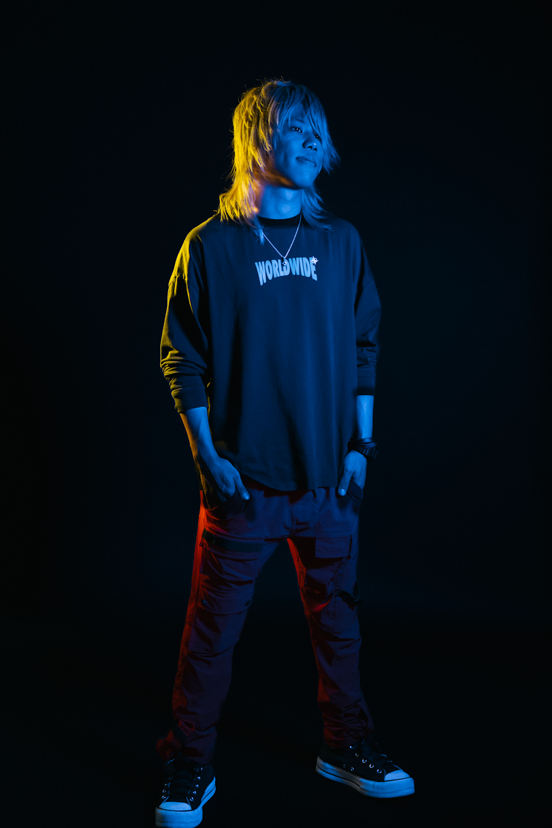 Kazuki standing in a dark room with not much light