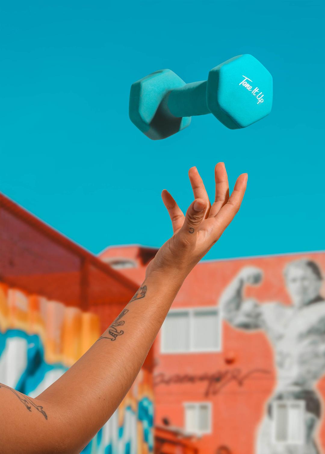 An arm throwing a small dumbbell into the air