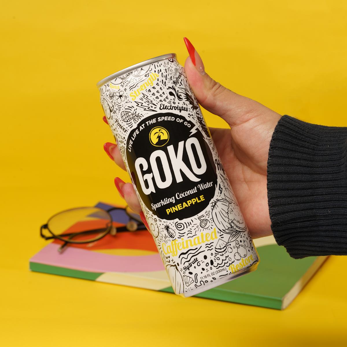 A hand holding a can of a pineapple flavored energy drink