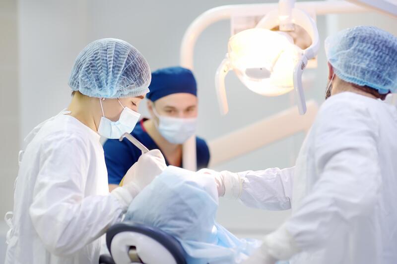 Dentiste chirurgien procédant à une greffe de gencive dans une salle opératoire