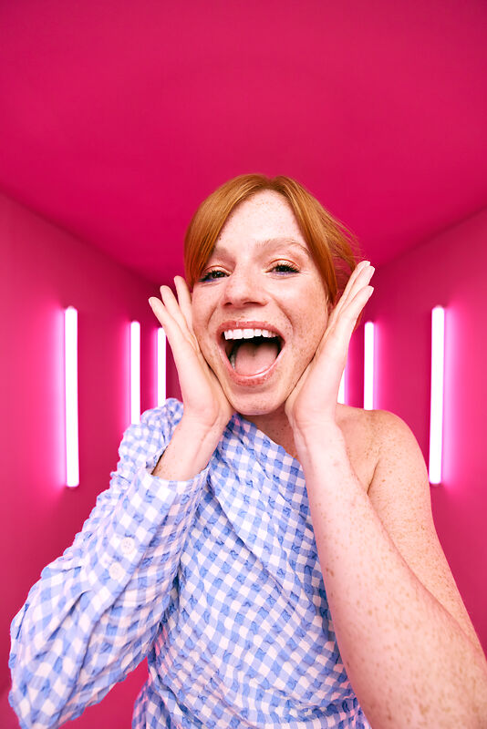[CRO] Woman - Ginger - Checkered shirt - Freckles - Open mouth - Scream - Hands on face - Looking to camera - Pink - Light - Background - Desktop