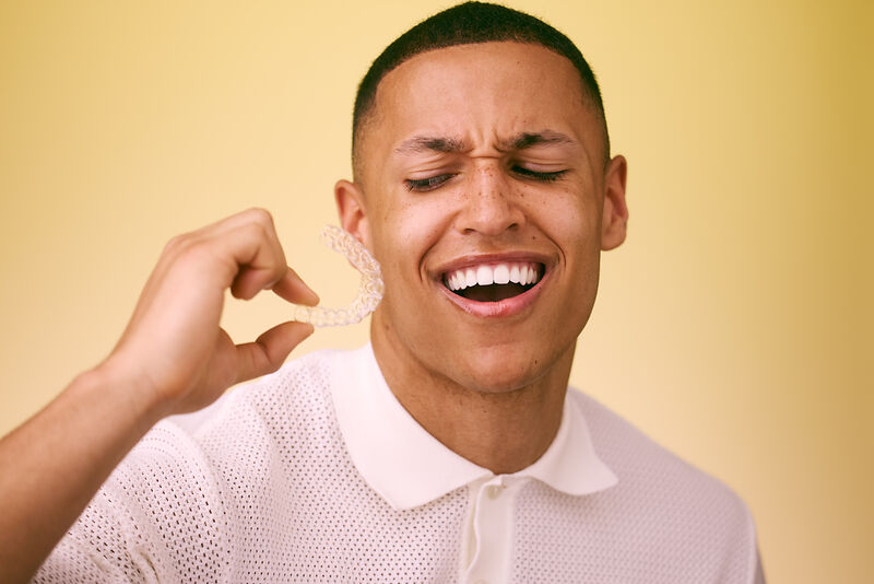 [CRO] Man - eyes closed - side eye - aligners - hand - touching face - white shirt - yellow - background - desktop