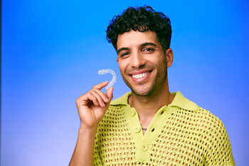[CRO] Man - Brunette - Curly hair - Smile - Aligner - Looking front - Green - Knitting - T-shirt - Blue - Gradient - Background - Mobile