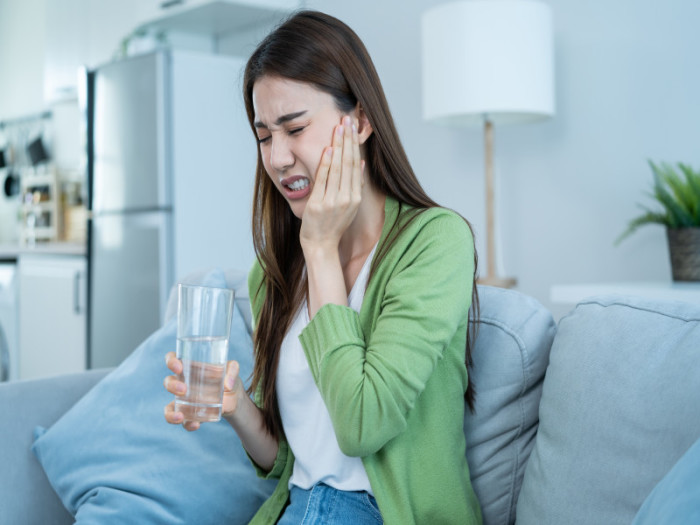 Mujer asiática con dolor causado por dientes apiñados