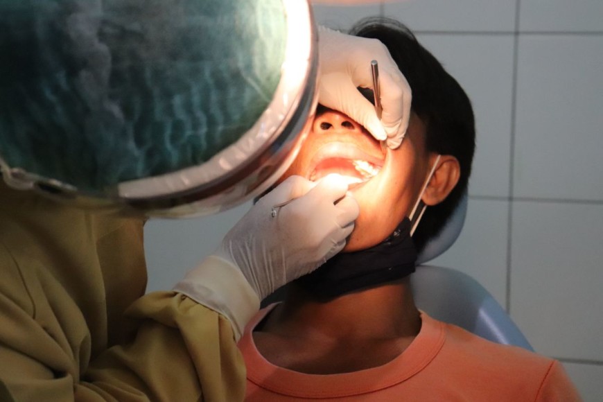 Patiente pendant une consultation chez le dentiste pour une carie - Photo par Mufid Majnun
