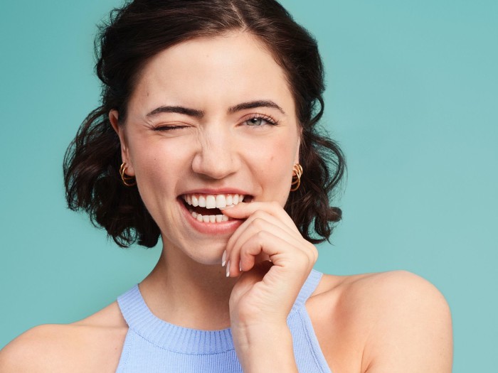 Frau setzt unsichtbare Zahnschiene von DR SMILE zur Zahnkorrektur ein