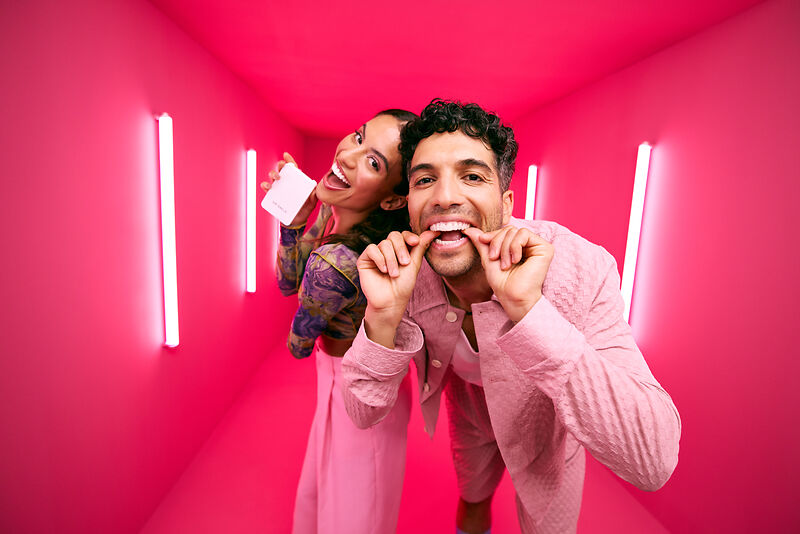 [CRO] Woman - Man - Brunettes - Case - Aligner on - Smile - Standing - Pink - Light - Background - Desktop