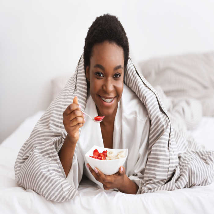 Mujer afroamericana comiendo con brackets