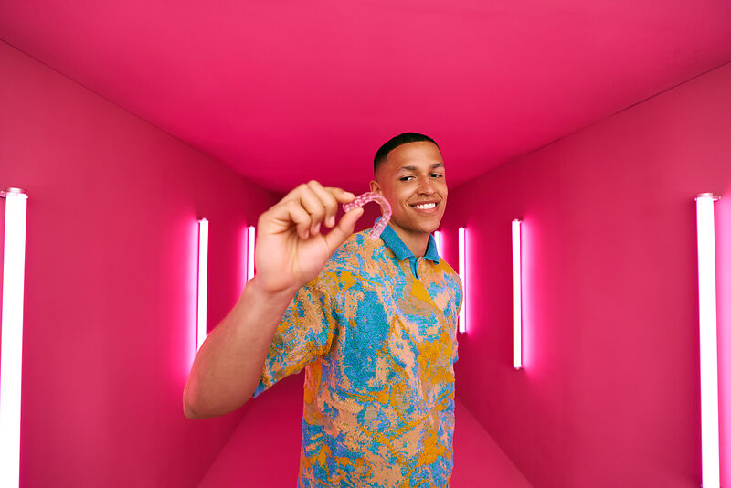 [CRO] Man - Aligner - In front - Hand - Look to the aligners - Pink - Light - Background - Desktop