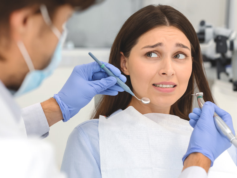 Mujer en el dentista con expresión de miedo