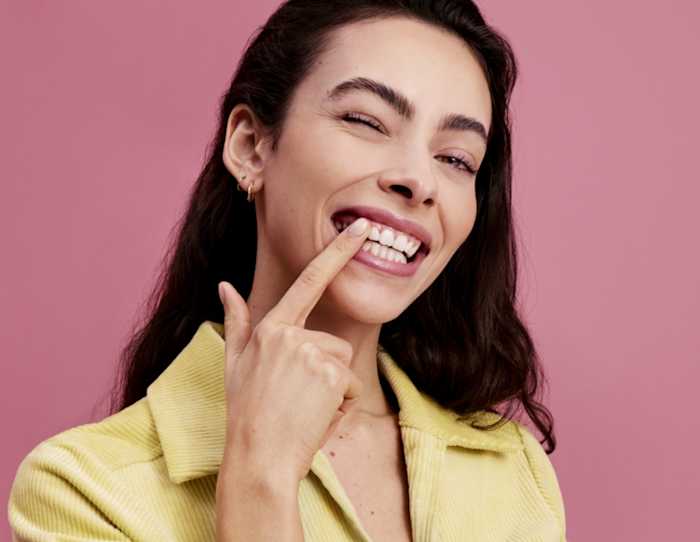 Mujer sonrientes con fondo rosa