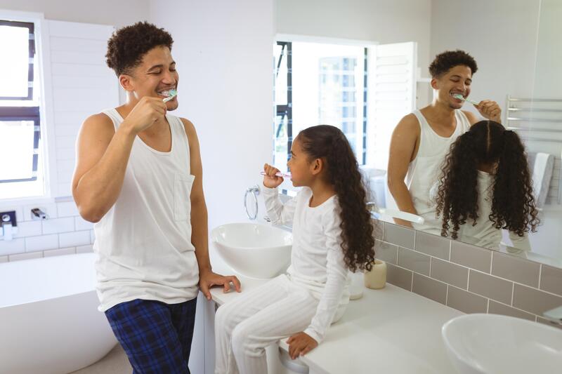 Père et fille brossant leur dents ensemble