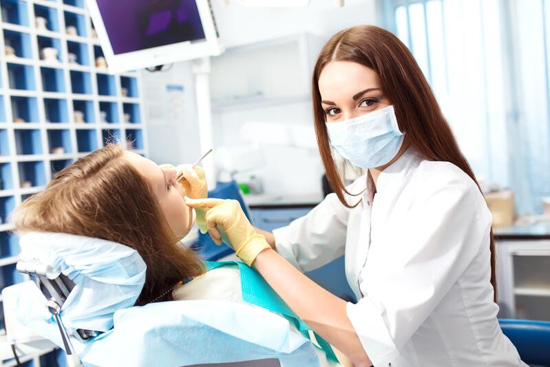 Dentiste vérifiant les abcès à la gencive d'une patiente