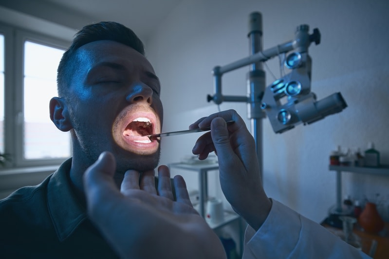 Homme lors d'un examen bucco-dentaire chez un dentiste