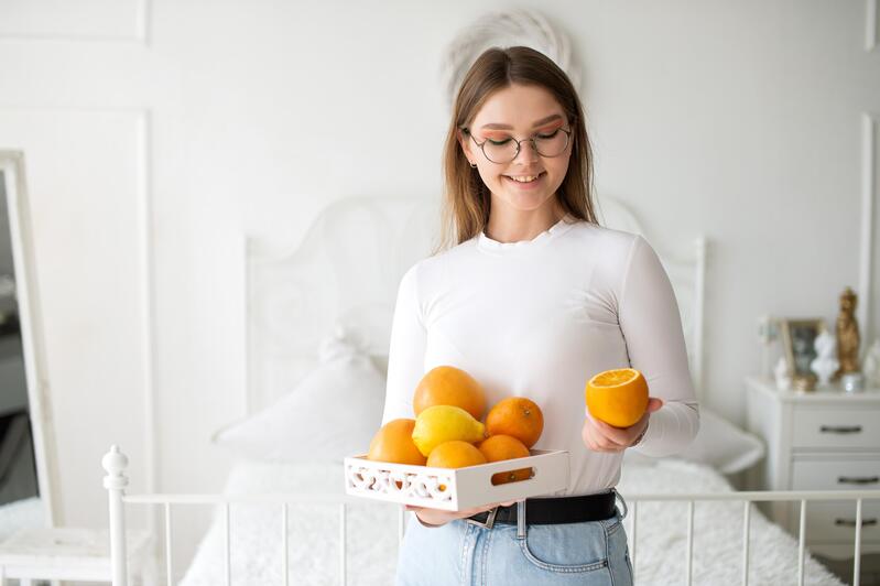 Meisje met sinaasappelen in de hand