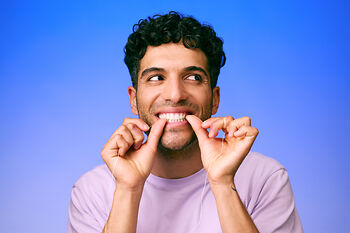 [CRO] Man - Brunette - Curly hair - Dental floss - Looking left - Lilac - T-shirt - Blue - Gradient - Background - Mobile