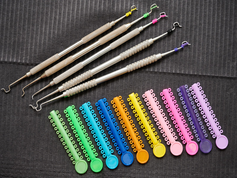 Diversi colori di elastici ortodontici e applicatori