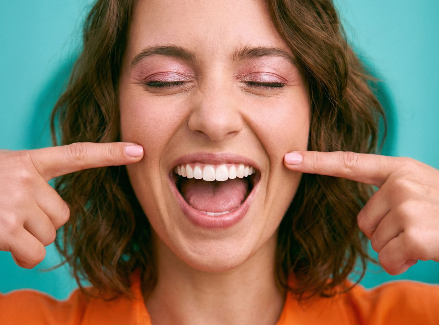 [CRO] Woman - Orange t-shirt - Smile - Aligner - in front - zoom - Looking down - Pink - Lights - Background - Desktop