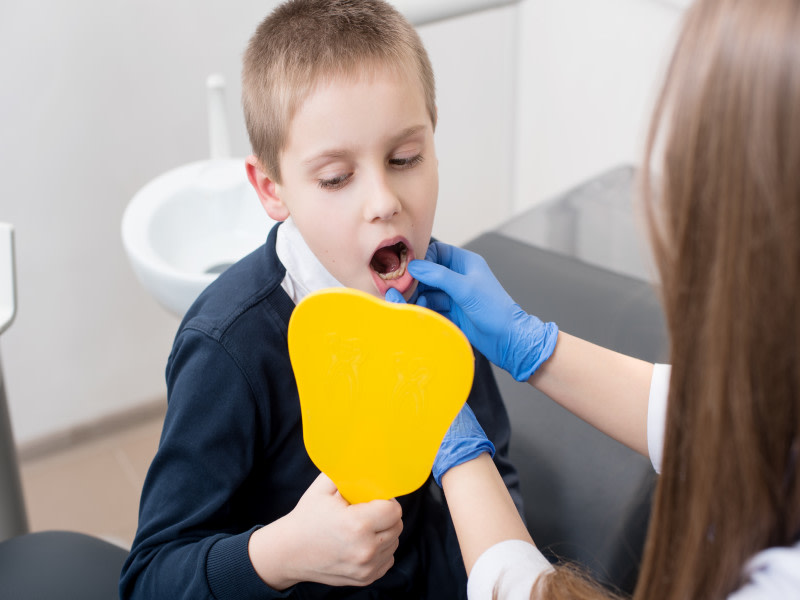 Bambino mostra i denti al dentista