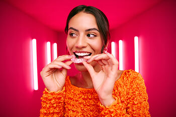 [CRO] Women - Brunette - Orange - Long sleeve - Aligners - Looking right - Pink - Light - Background - Mobile