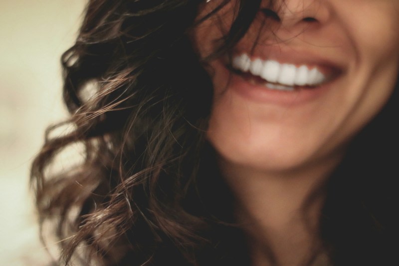 Photo en gros plan d'une femme souriant aux dents dévoilées, photo par Lesly Juarez via Unsplash