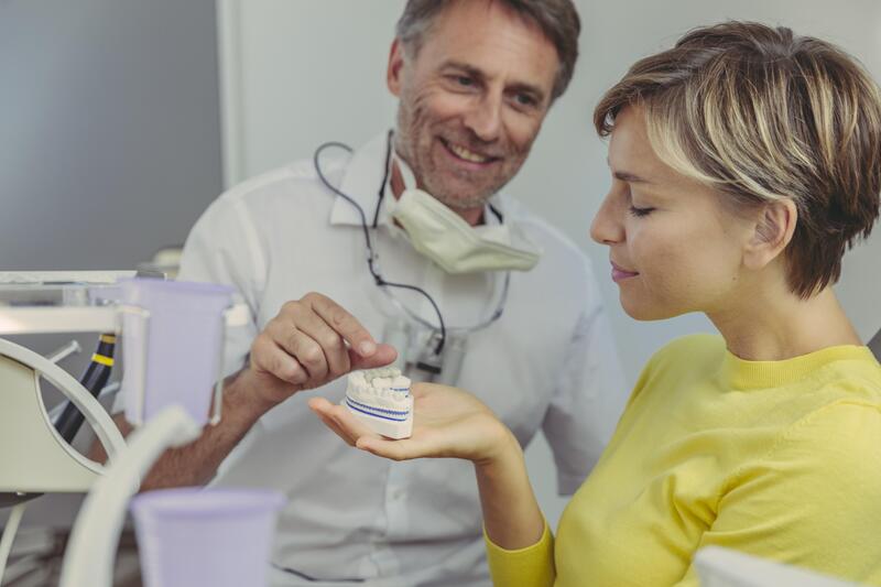Dentista mostra ponte dentale a paziente