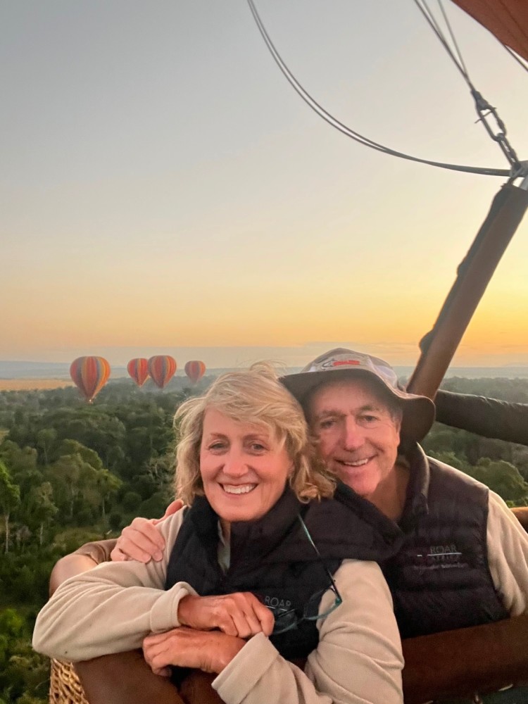 Couple Smiling on Hot Air Balloon Ride Showing Hot Air Balloons in Background - ROAR AFRICA