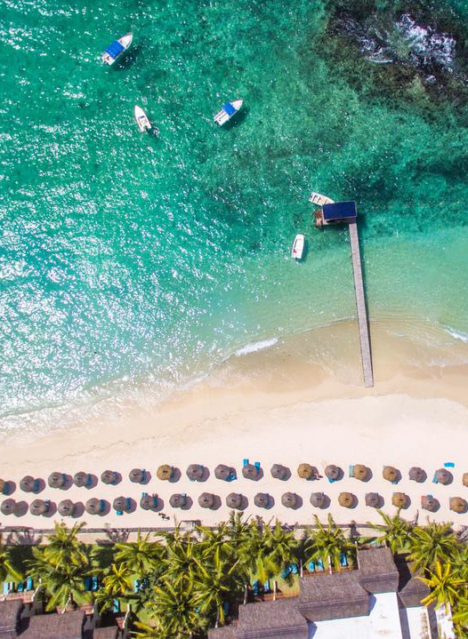 Bird's Eye View of Beachfront with Umbrellas and Shoreline down Coast of Mauritius