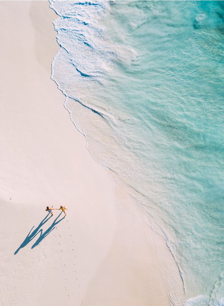 Aeriel View of Couple Walking along Shoreline of Beach on Safari in Seychelles - ROAR AFRICA