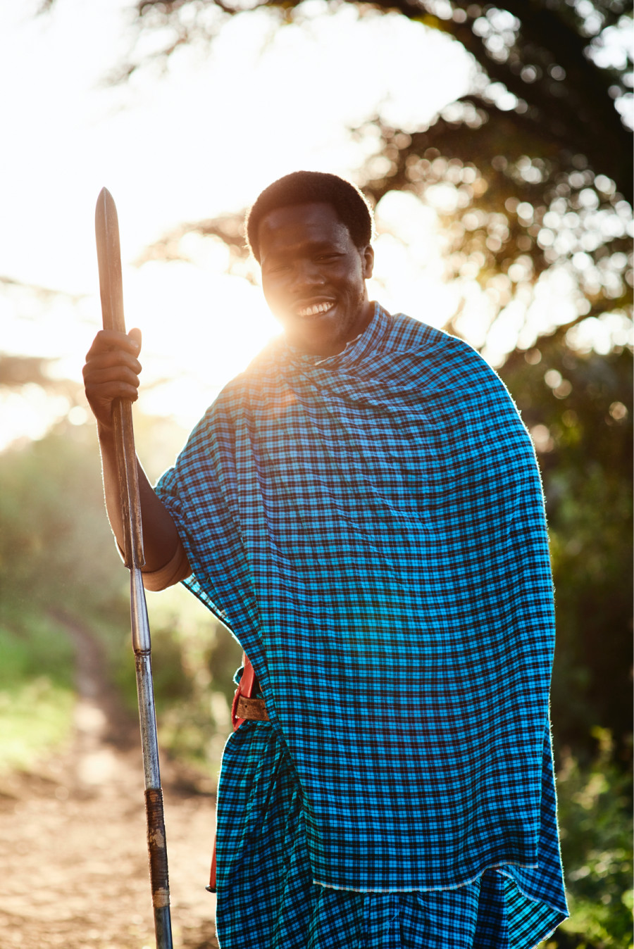 Man Standing Holding Staff Wearing Authentic Garb on Tanzania Safari - ROAR AFRICA