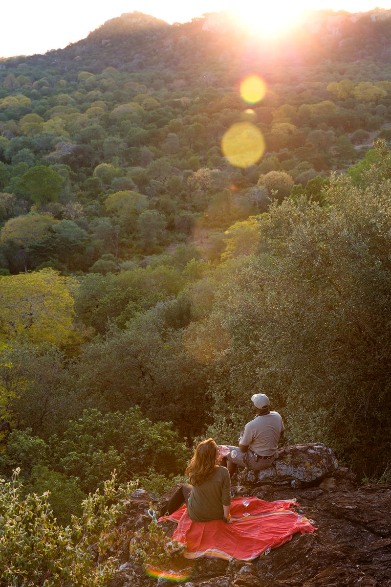 two people watching sunset in the bush
