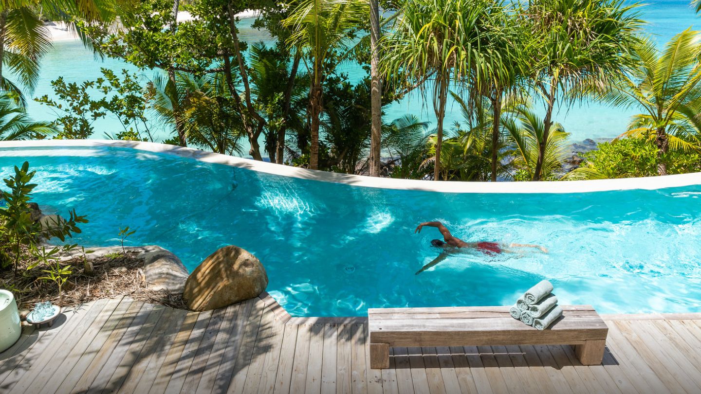 Guest Swimming in Luxury Pool on Safari in Seychelles with Crystal Clear Blue Water - ROAR AFRICA