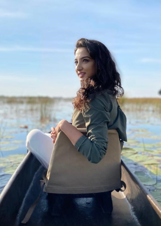 Woman on Safari Excursion in Botswana - Sitting in Canoe looking Backwards at Camera - ROAR AFRICA