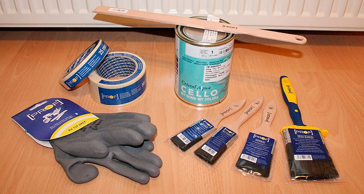Puulattialla teippirullia, harmaat työkäsineet, turkoosi maalipurkki ja puusiveltimiä.