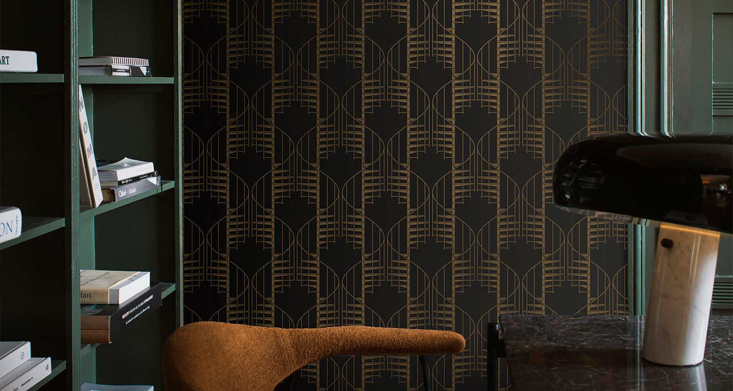 Vihreät hyllyt kirjoineen, mustakultainen art déco -tapetti, ruskea nojatuoli, marmorialuslamppu