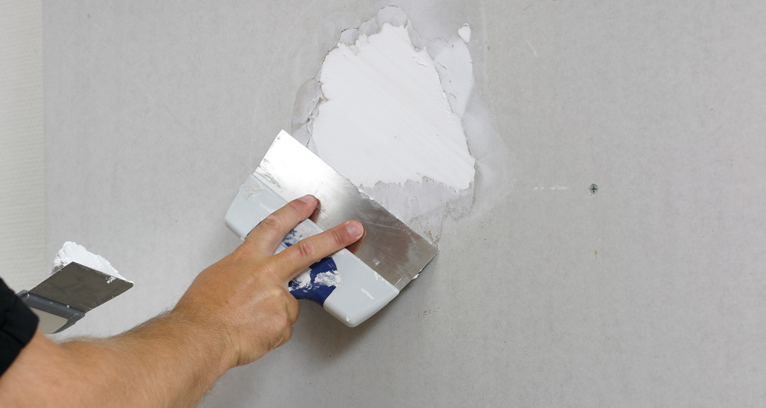 Maalari paikkaa seinää Casco Onefill -tuotteella.